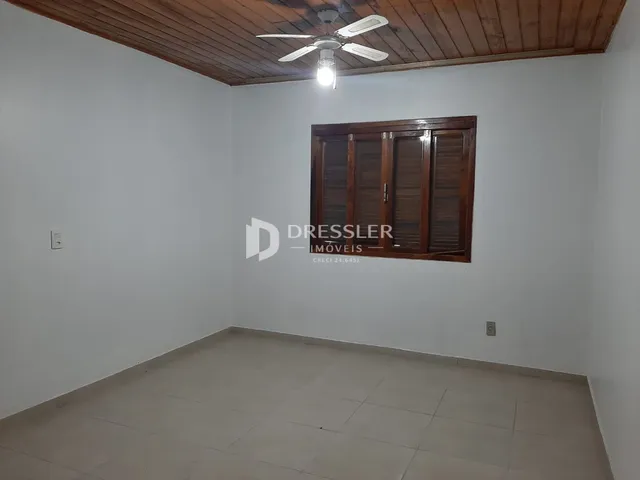 Ambiente interno de uma sala com piso de cerâmica e teto de madeira.