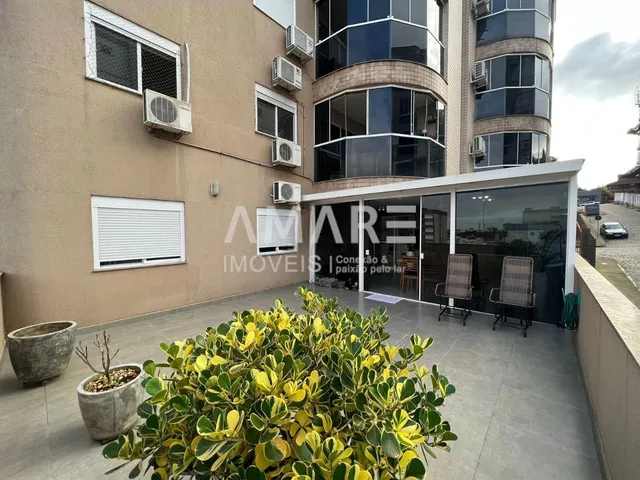 Fachada de um prédio residencial em Lajeado, Brasil, com área externa e vegetação.