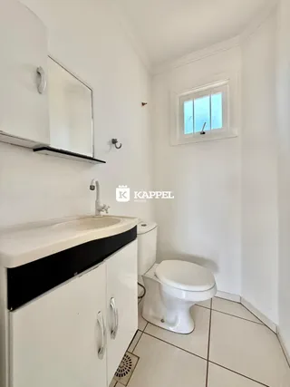 Banheiro com pia e vaso sanitário em um imóvel.
