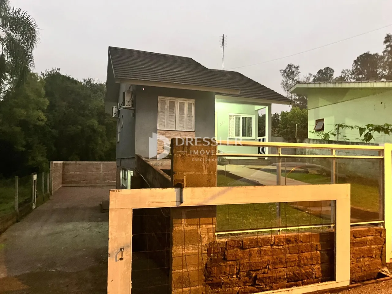 Fachada de uma casa em Lajeado, Brasil, com portão de acesso de metal.