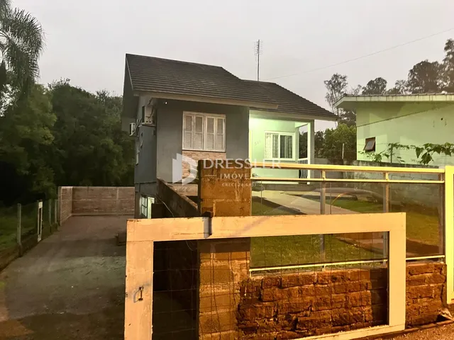 Fachada de uma casa em Lajeado, Brasil, com portão de acesso de metal.