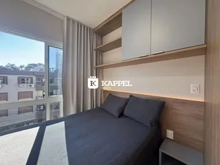 Quarto com cama de casal e grande janela com vista para o exterior.