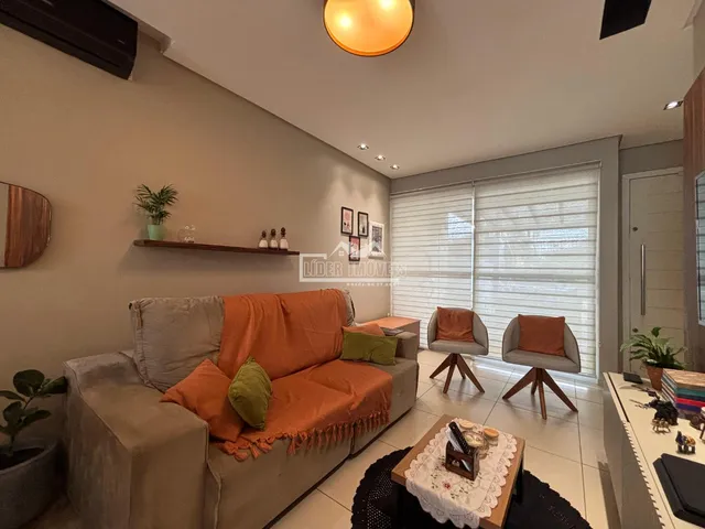 Foto interna de uma sala de estar com sofá e poltronas.