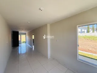 Corredor interno de um imóvel com piso de cerâmica.