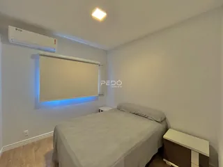 Quarto com cama e televisão na parede em um imóvel no Brasil.