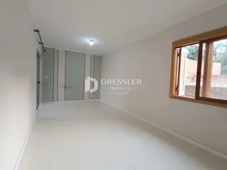 Vista interna de um ambiente com paredes brancas e armários embutidos.