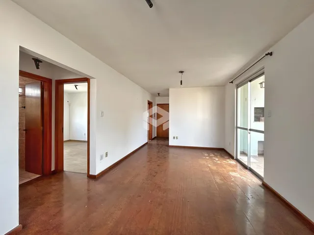 Hall de entrada com piso de madeira e paredes brancas.
