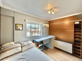 Quarto com cabeceira e armário em um ambiente moderno.