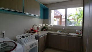 Vista da cozinha com armários e máquina de lavar roupa.