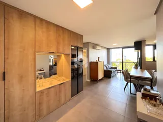 Sala de estar e cozinha com portas de vidro que dão para a varanda.