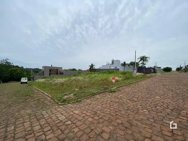 Vista externa de um terreno com grama e um caminho de tijolos.