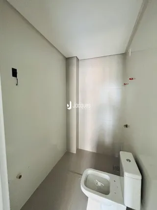 Vista de um corredor interno com um banheiro adjacente.