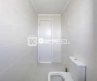 Foto interna de um banheiro branco com vaso sanitário.