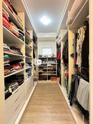 Hall de entrada com estantes cheias de roupas.