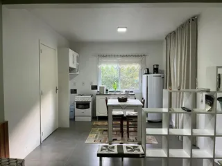 Cozinha moderna com armários brancos e ilha central em um apartamento.