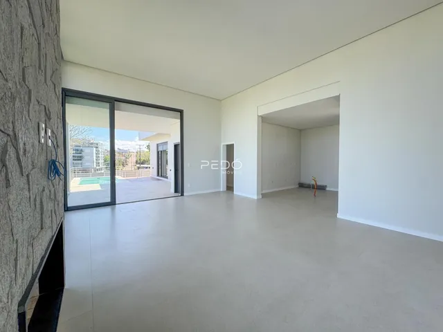 Ambiente interno de uma sala com portas de vidro que dão acesso a uma área externa.