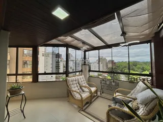 Sala de estar com vista para a paisagem urbana através de grandes janelas.