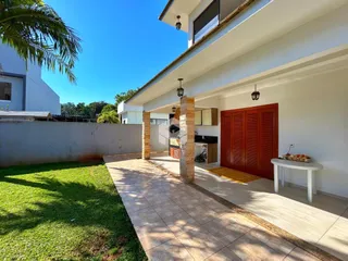 Fachada de uma casa em Lajeado, Brasil, com jardim gramado e área coberta.