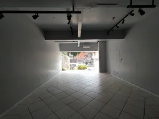 Corredor interno com piso de cerâmica e porta de saída.