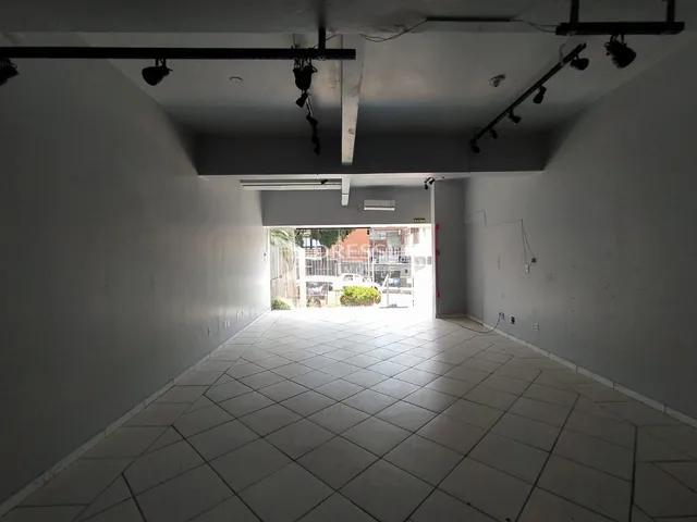 Corredor interno com piso de cerâmica e porta de saída.