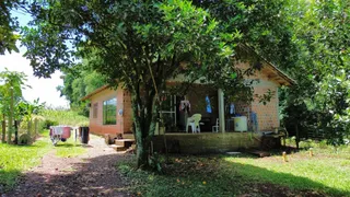 Fachada de uma residência de alvenaria com vegetação ao redor.