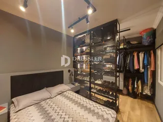 Quarto com cama e armário de metal em um ambiente moderno.