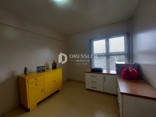 Quarto interno com móveis amarelos e janela na sala.