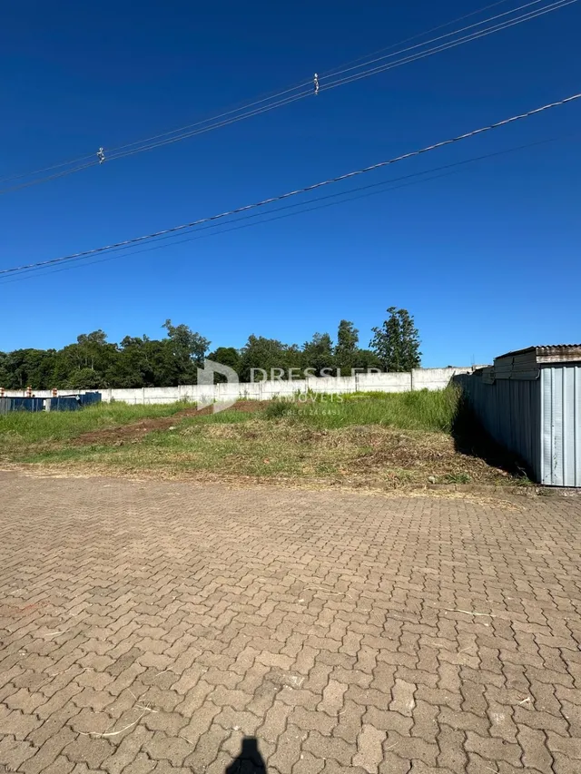 Vista externa da propriedade com grama e cerca.