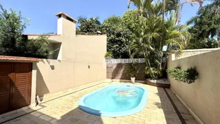 Uma foto da área externa com piscina e jardim de uma propriedade.