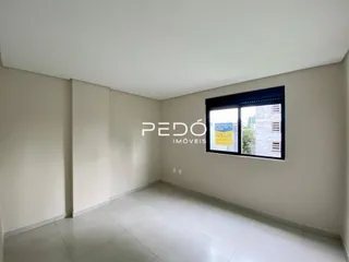 Vista interna de uma sala com paredes brancas e piso claro.