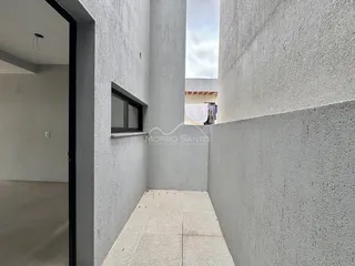 Corredor interno com paredes de estuque claro e piso de cerâmica.
