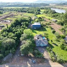 Vista aérea de uma propriedade rural em Lajeado, Brasil, mostrando vegetação e área aberta.