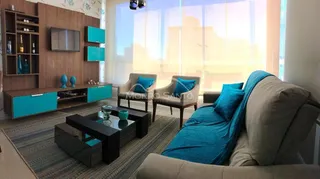 Sala de estar com sofá e móveis modernos em um apartamento.