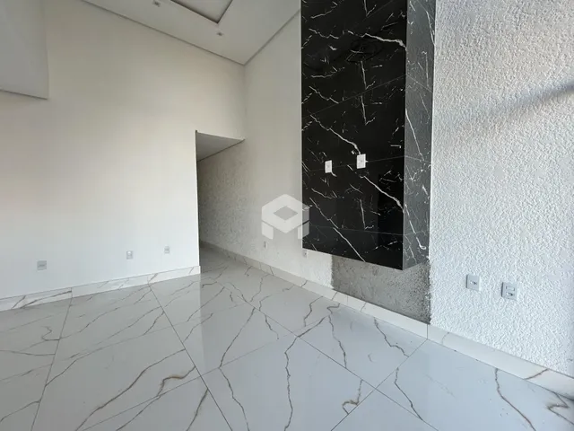 Corredor com paredes brancas e piso de mármore claro.