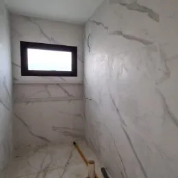 Interior de um corredor com paredes revestidas em mármore branco.