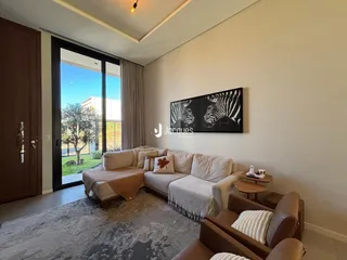 Sala de estar com sofá e grande janela de vidro.
