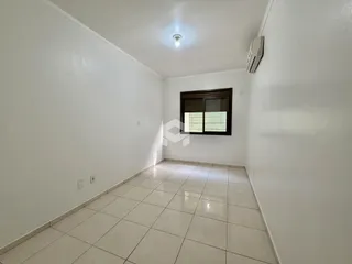 Corredor interno com paredes brancas e piso de cerâmica.