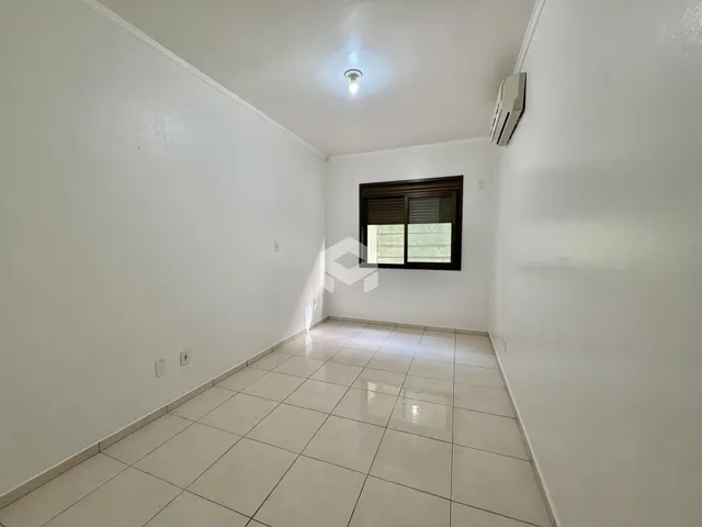 Corredor interno com paredes brancas e piso de cerâmica.