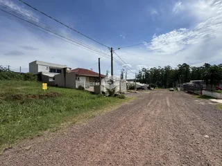 Vista externa de casas em uma área rural com estrada de terra.