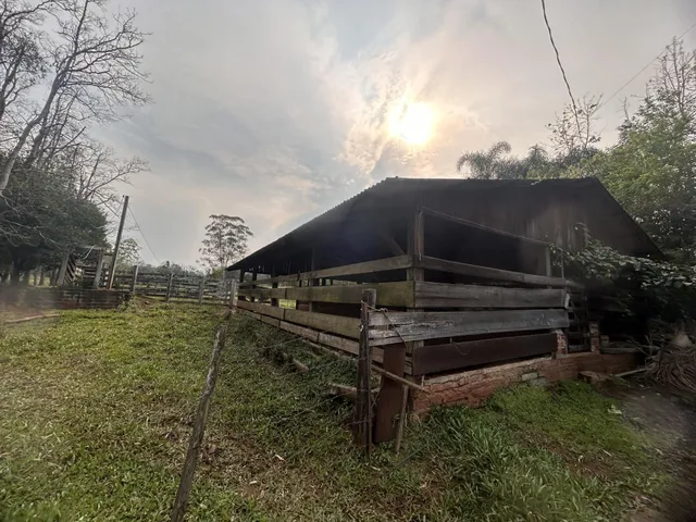 Fachada rústica de uma casa de madeira em uma área gramada.