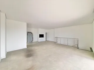 Foto de uma sala ampla com piso de porcelanato claro.