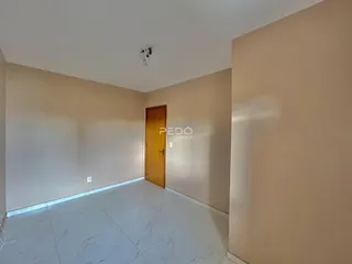 Hall de entrada com piso de porcelanato claro e porta de madeira.