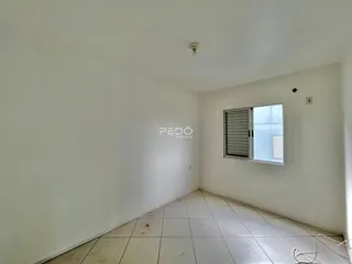 Vista de um corredor interno com piso de cerâmica clara.