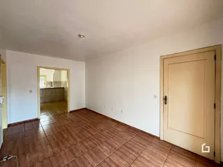 Corredor interno com piso de cerâmica em tom terracota.