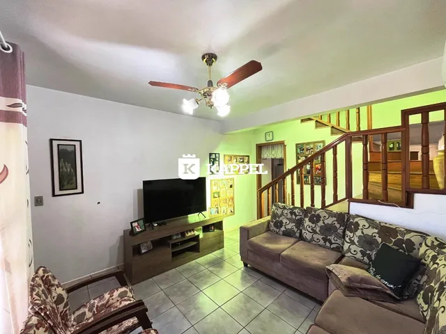 Sala de estar com sofá e televisão em um apartamento.
