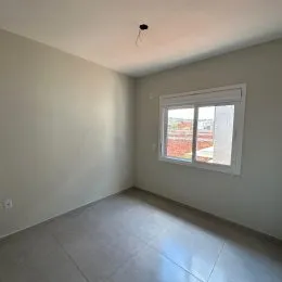 Foto de um cômodo interno com uma janela que mostra uma vista externa.