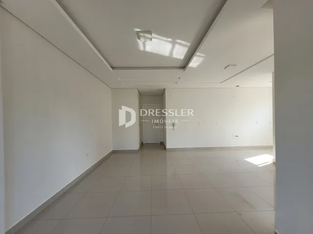 Hall de entrada longo com piso de cerâmica claro.