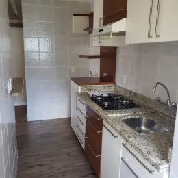 Cozinha com bancada e armários de madeira em um ambiente interno.
