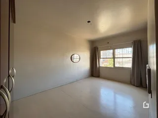 Vista interna de um cômodo com parede branca e piso claro.