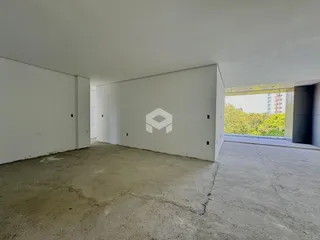 Imagem de um espaço interno com paredes brancas e piso de concreto.